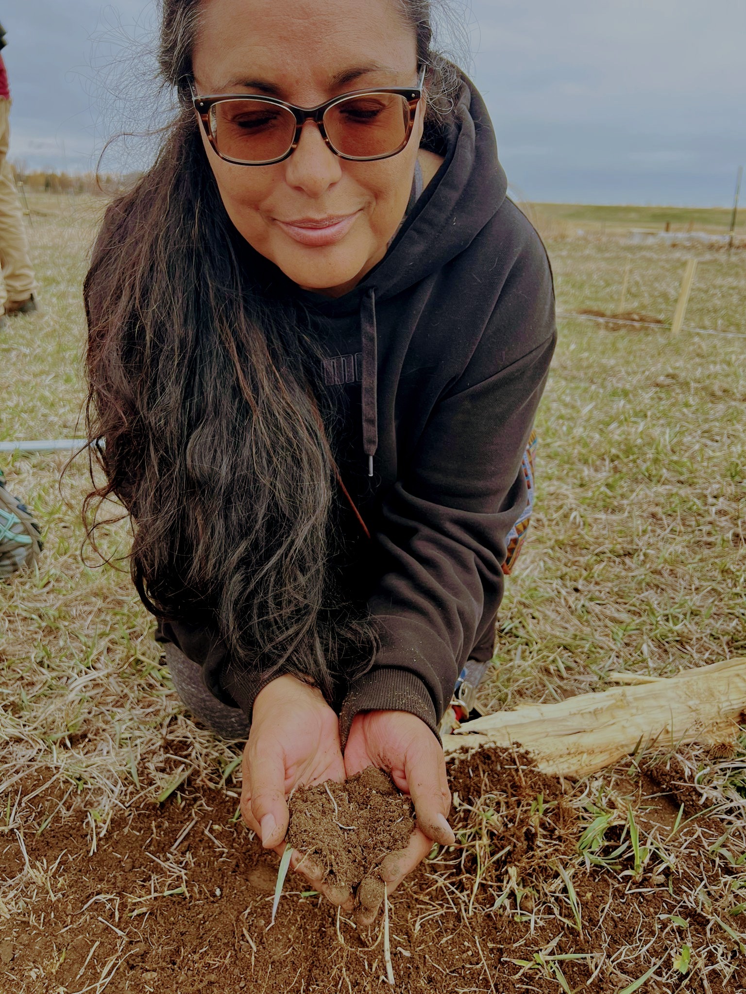 Beverly Castaneda with her hands in the soil